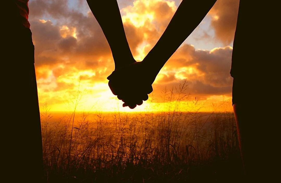 Couple holding hands at sunset - intimacy and sexual health